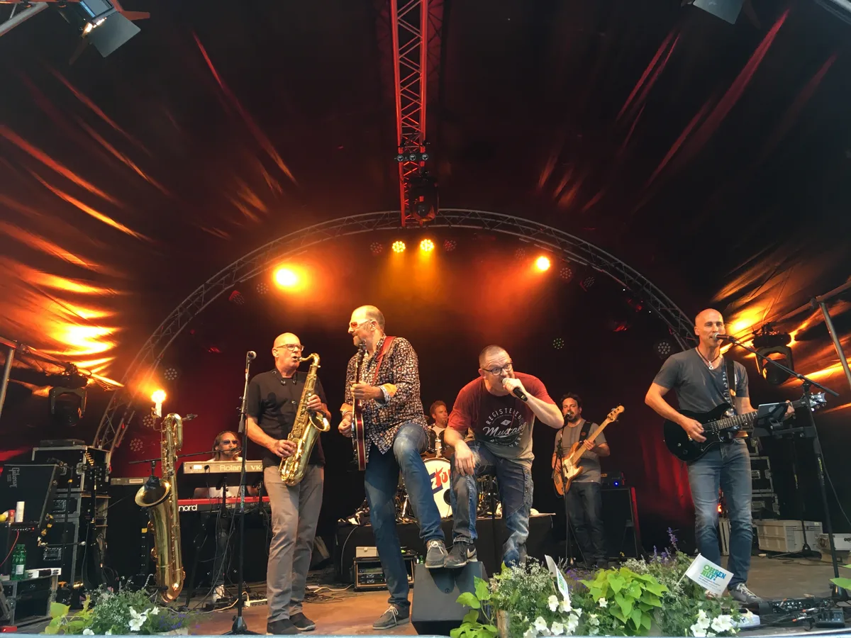 Man sieht eine Band auf einer Bühne.