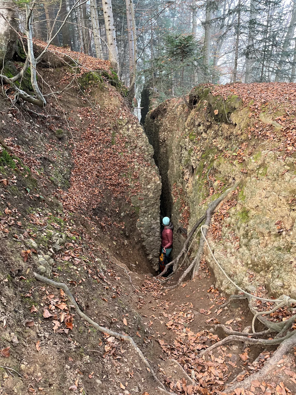 Man sieht eine Spalte von einem Felsen und einen Menschen davor.