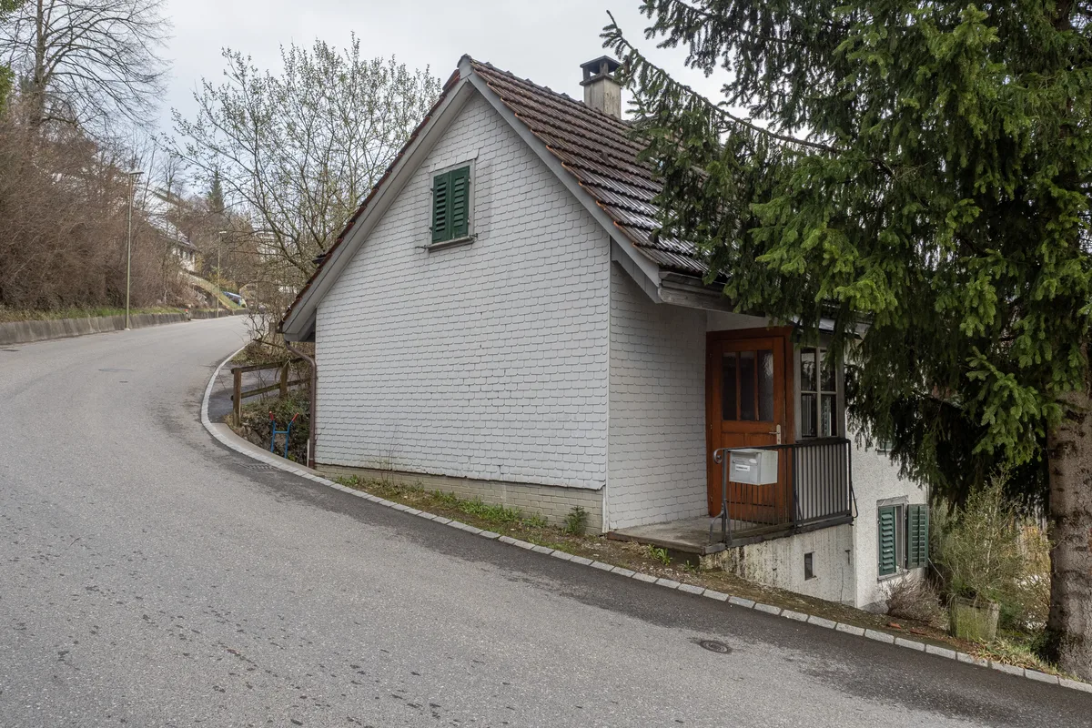 Viel Spielraum für bauliche Massnahmen gibt es nicht, solange das Haus steht. Man sieht ein Haus, das in einer Kurve direkt an der Strasse steht.