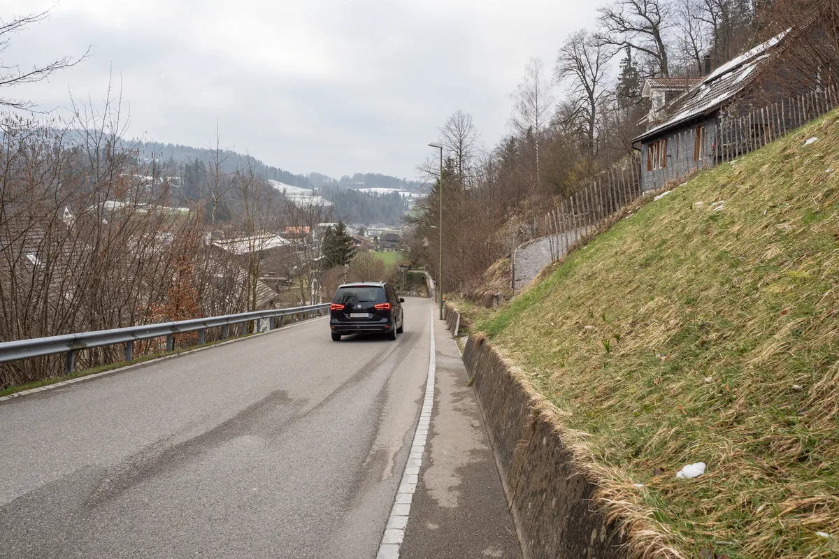 Die Ist-Situation zeigt: Entlang der Sternenbergstrasse bleibt nicht viel Platz für die Fussgänger. Man sieht eine Strasse, auf der ein Auto fährt.