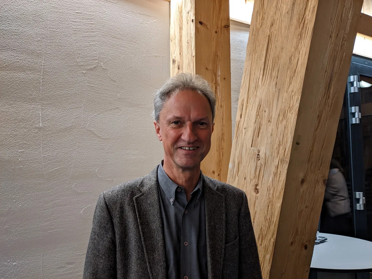 Bernhard Egg ist Jurist und Mitglied im Stiftungsrat des Gehörlosendorfs. Mann vor Balkenkonstruktion