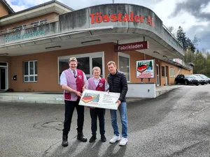 24151062-4 Erich Bleicher (links) und sein Sohn Linus (Mitte) nehmen die Firmentafel von Adrian Lötterle (rechts) entgegen.