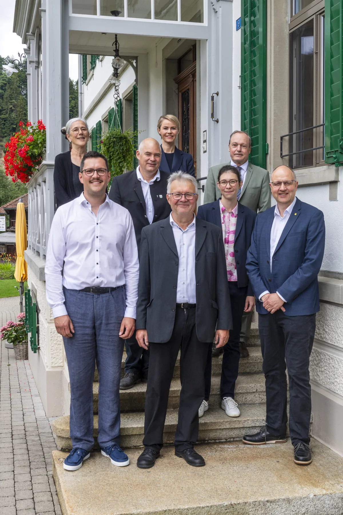 Die Ehrengäste sind eingetroffen. Natalie Rickli (oben, Mitte), Jörg Kündig (oben, rechts), Andreas Sudler (Mitte, links) und Markus Schaaf (vorne rechts), zusammen mit der Familie Graf. Die Blumenau in Bauma feiert ihr 130 jähriges Bestehen.