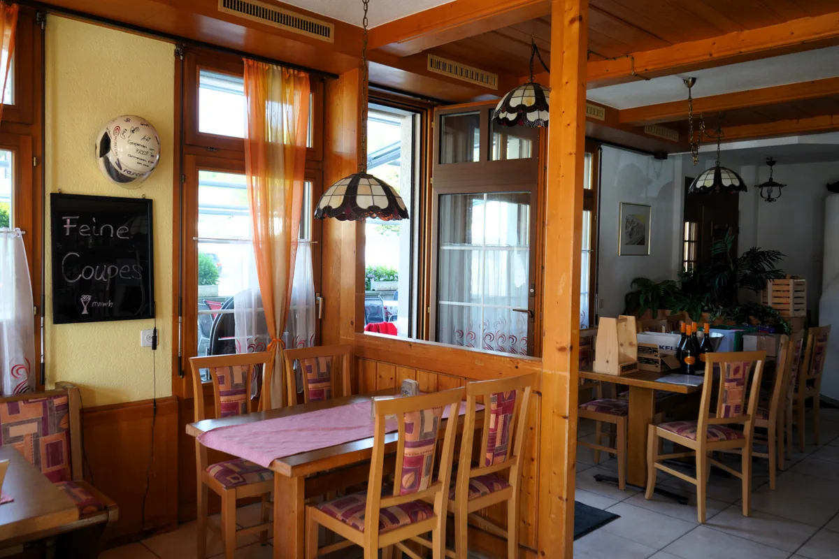 Man sieht die Inneneinrichtung eines Restaurants mit Tischen, Stühlen.