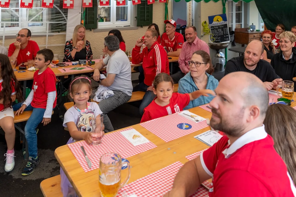 Menschen sitzen an Tischen.