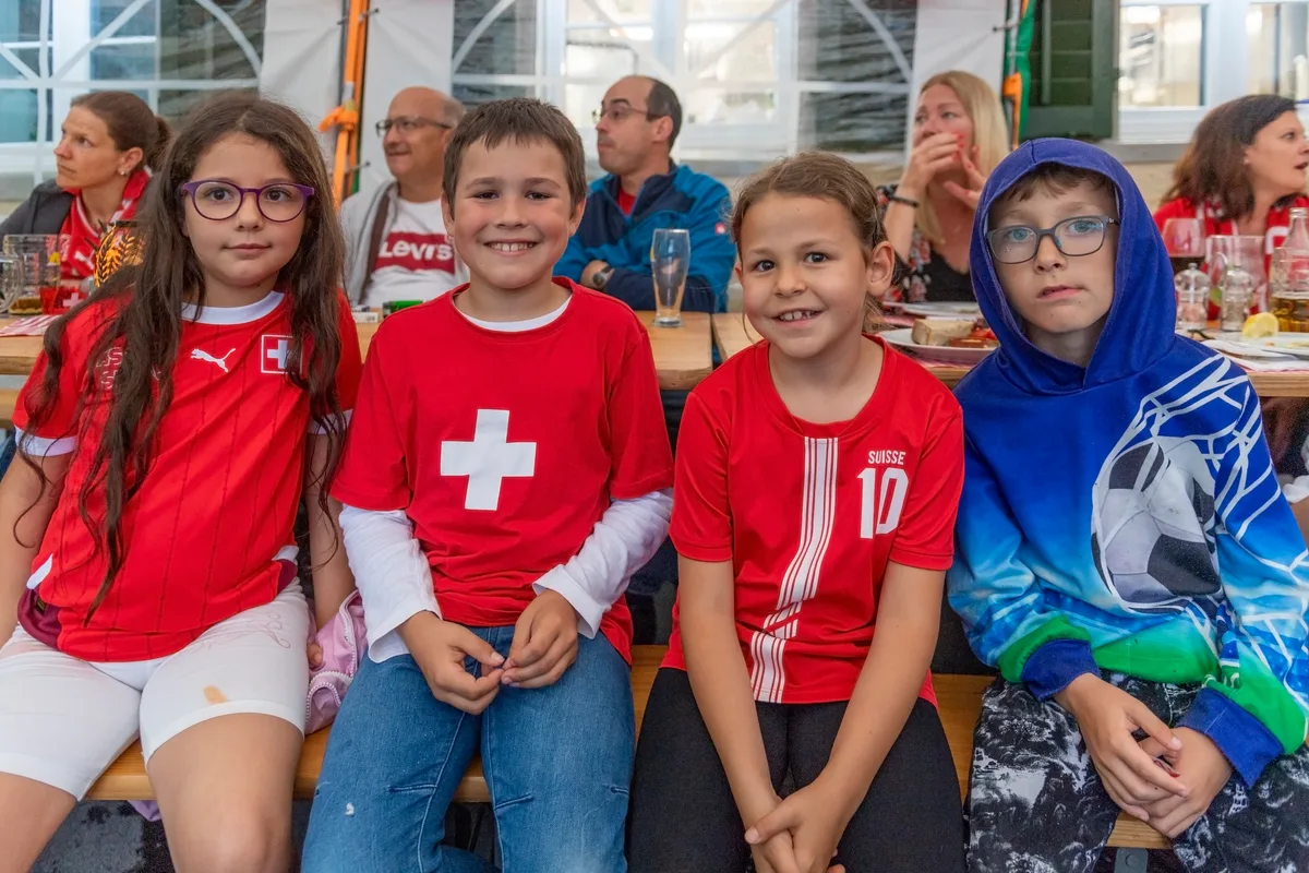 Kinder sitzen auf einer Bank.