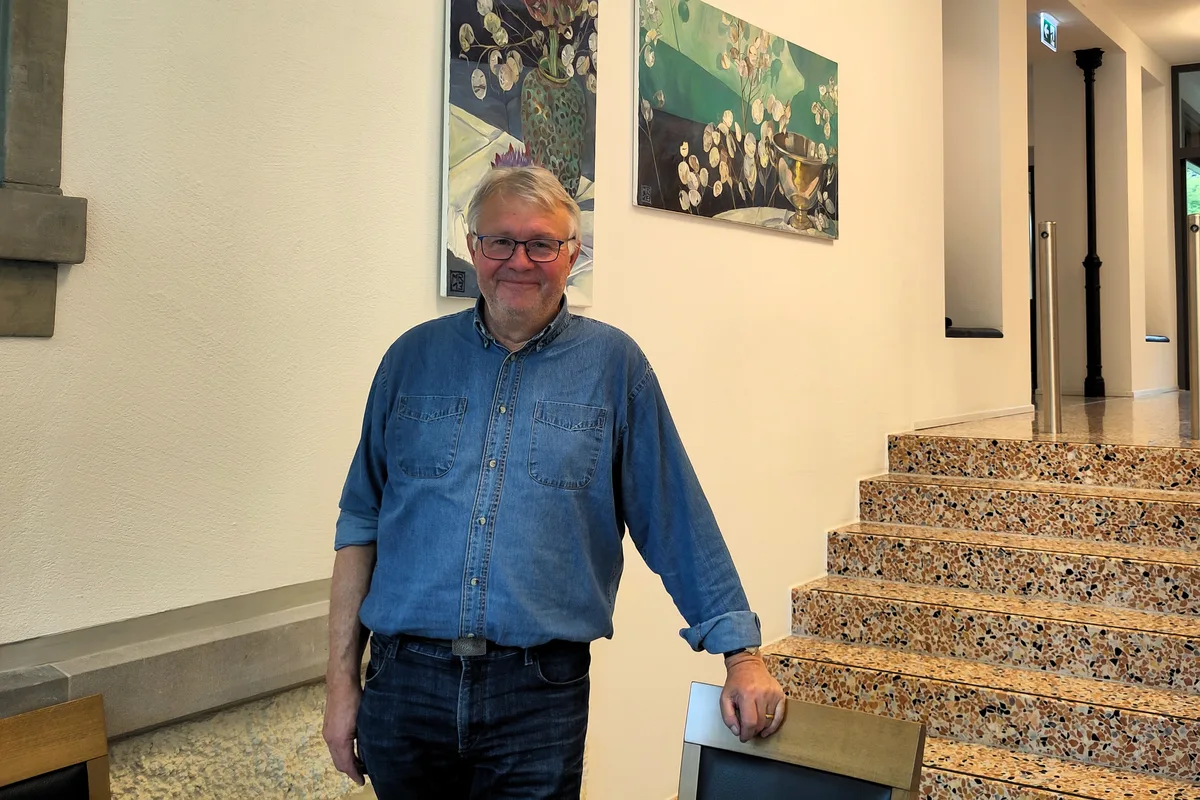 Felix Graf übernahm die Leitung des Heims in den Achtzigerjahren. Seither hat sich viel getan. Man sieht einen Mann, der sich auf einen Stuhl aufstützt.
