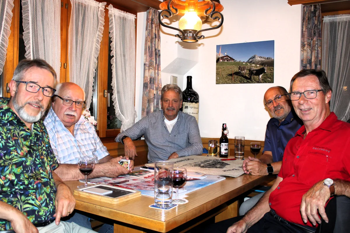 Man sieht fünf Männer an einem Jass-Tisch.