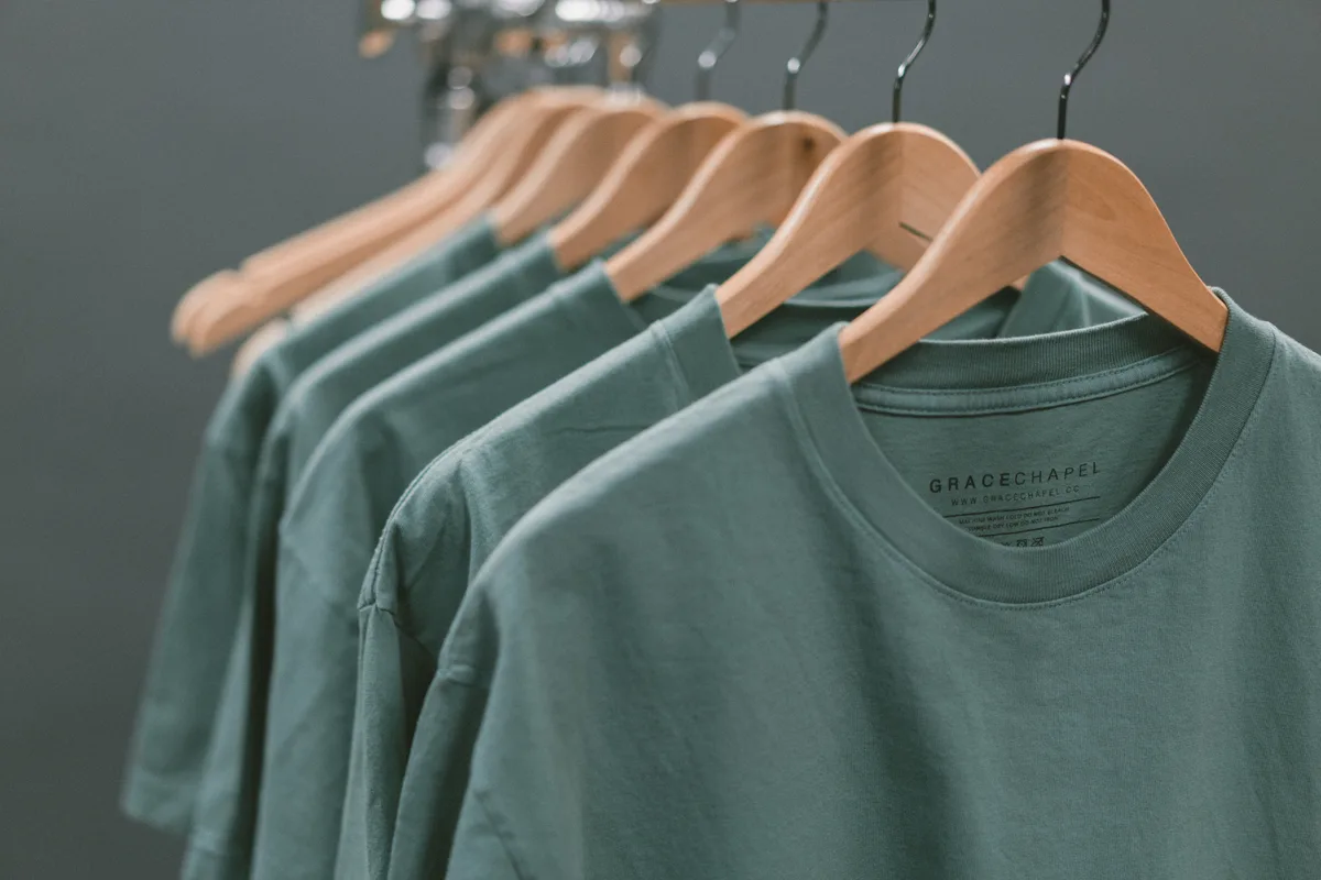 Mehrere gleichfarbige T-Shirts auf einer Kleiderstange.
