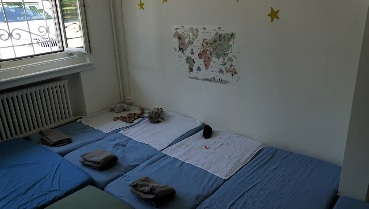 Man sieht ein Zimmer mit Matten auf dem Boden und Bettzeugs.