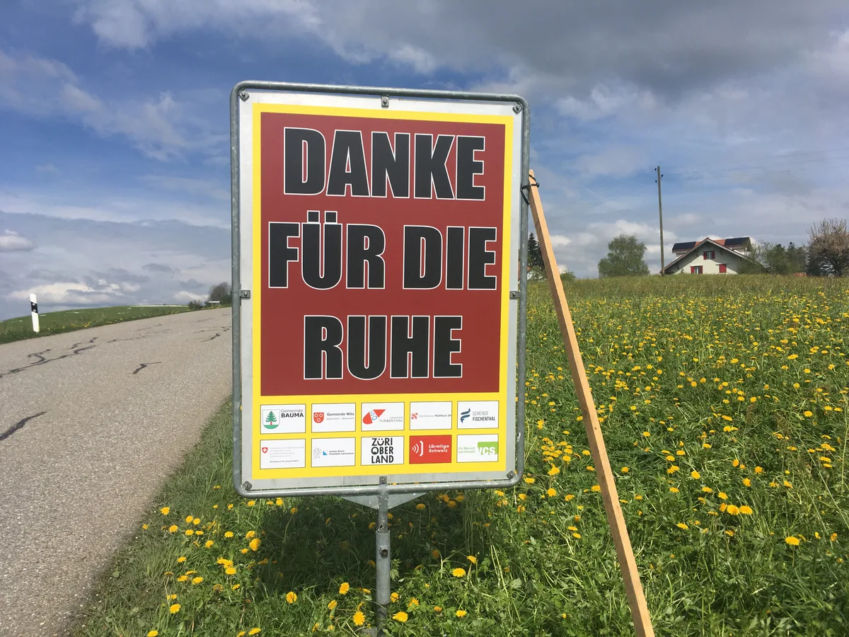 Man sieht ein Plakat mit grünem Hintergrund und der Aufschrift: «Danke für die Ruhe»