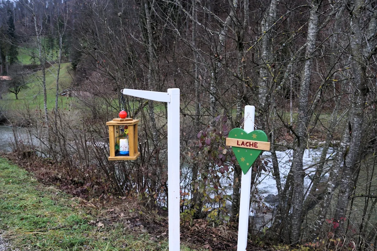 Man sieht eine Laterne und einen Pfosten, auf dem ein Herz aus Holz angebracht ist.