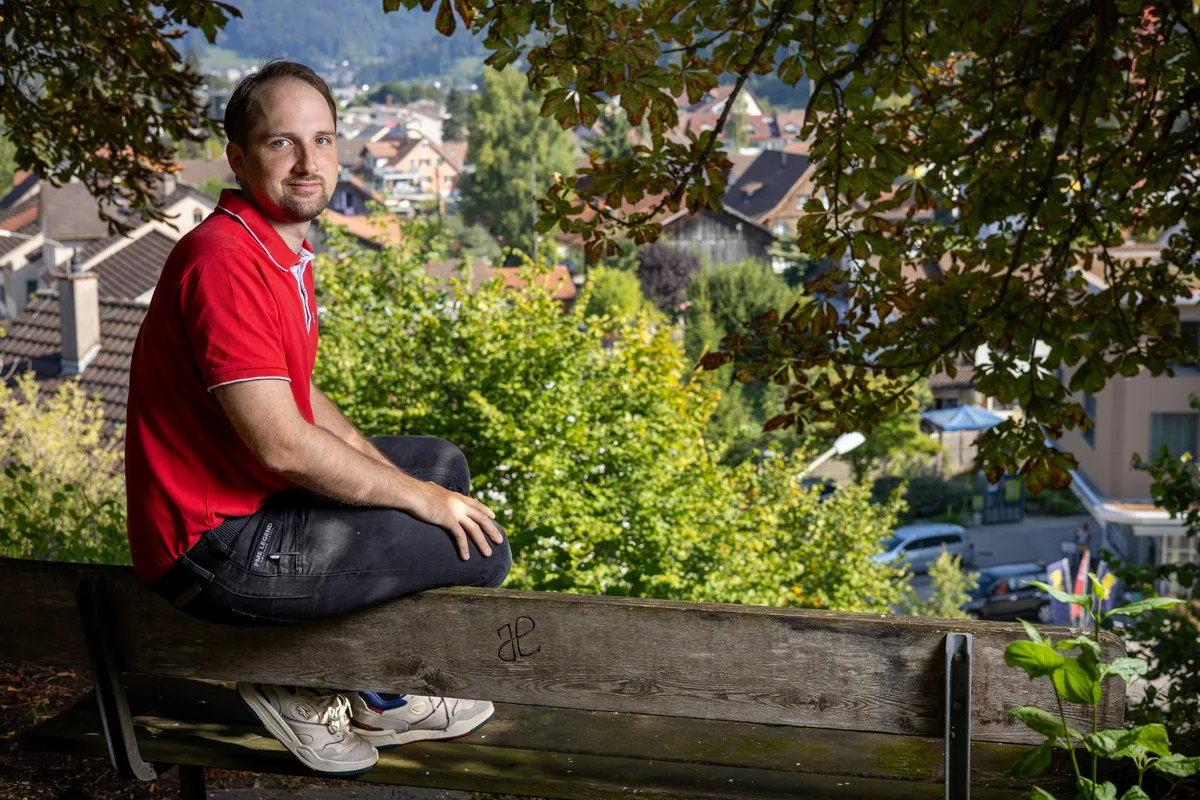 noneSimon Mösch auf dem Aussichtspunkt bei der Kirche Wila: Für das Dorf will er sich auch nach dem Rückzug im Sommer 2026 einsetzen. Man sieht einen Mann auf einer Bank sitzen.