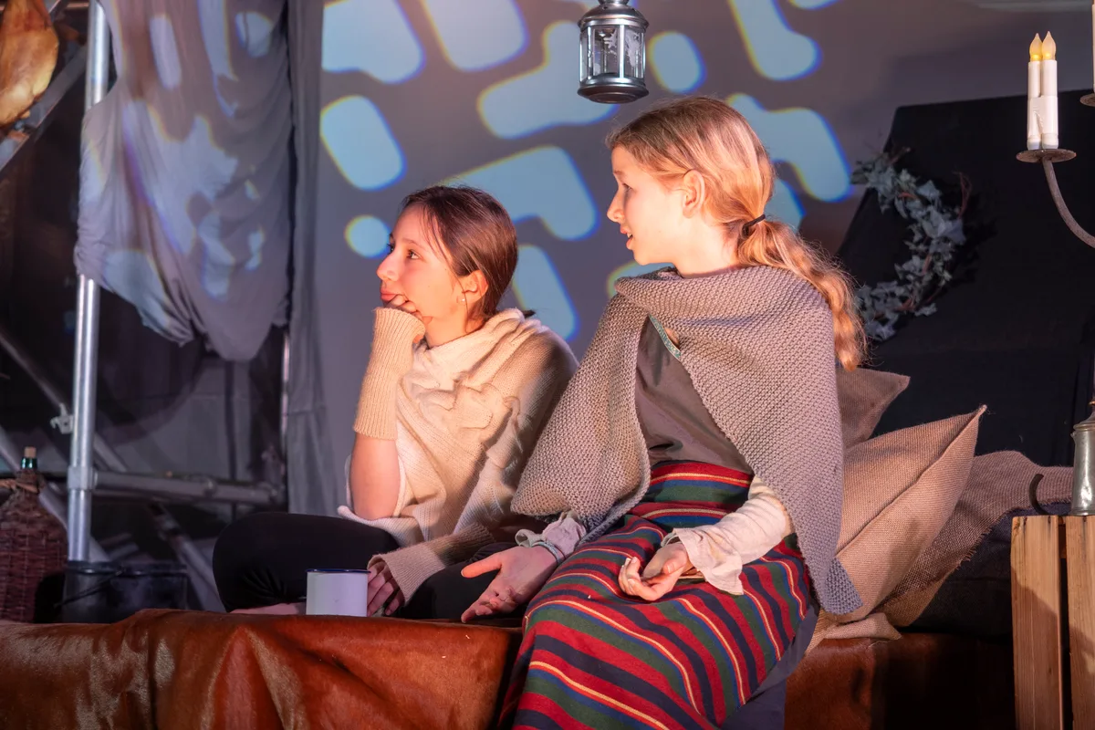 Ronja, inzwischen zum Mädchen herangewachsen, und ihre Mutter. Man sieht Kinder, die ein Theaterstück proben.
