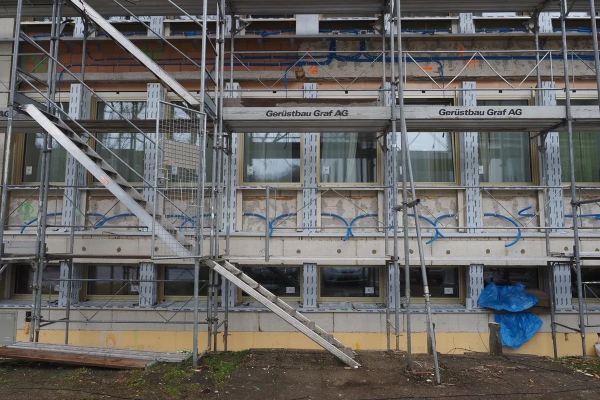 Man sieht eine Gebäudefront mit Baugerüst. Die Fassade fehlt.