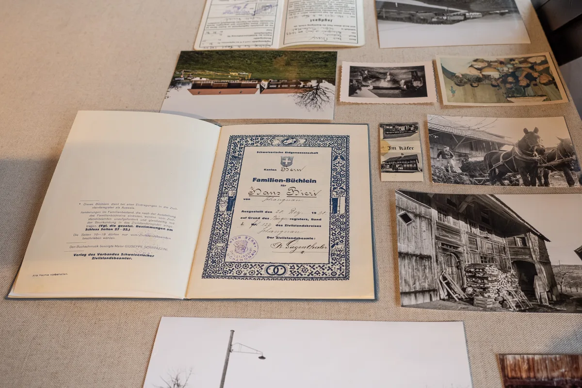 Man sieht ein geöffnetes Familien-Büchlein. Daneben liegen Schwarz-Weiss-Fotos.