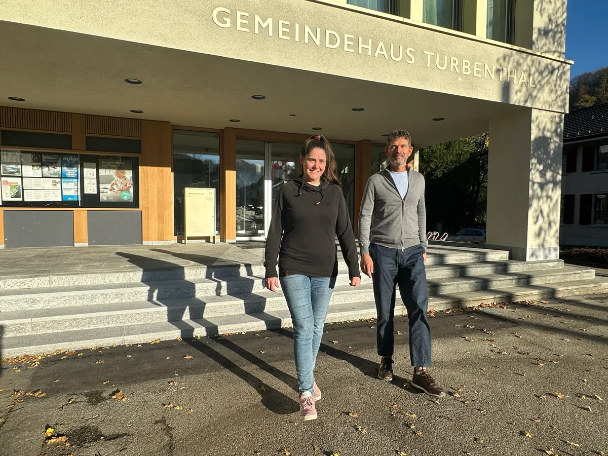 Ein Mann und eine Frau gehen vor einem Gebäude.