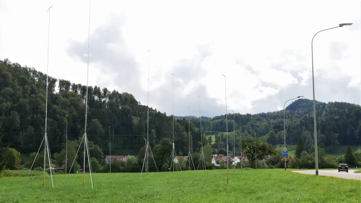 Man sieht mehrere Baugespanne auf einem unbebauten Stück Wiese.
