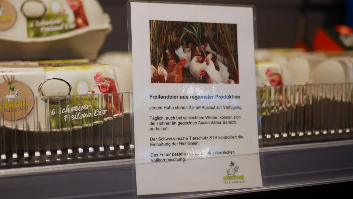 Man sieht Eier in einem Regal, mit einem Hinweis auf deren Produktionsbedingungen.