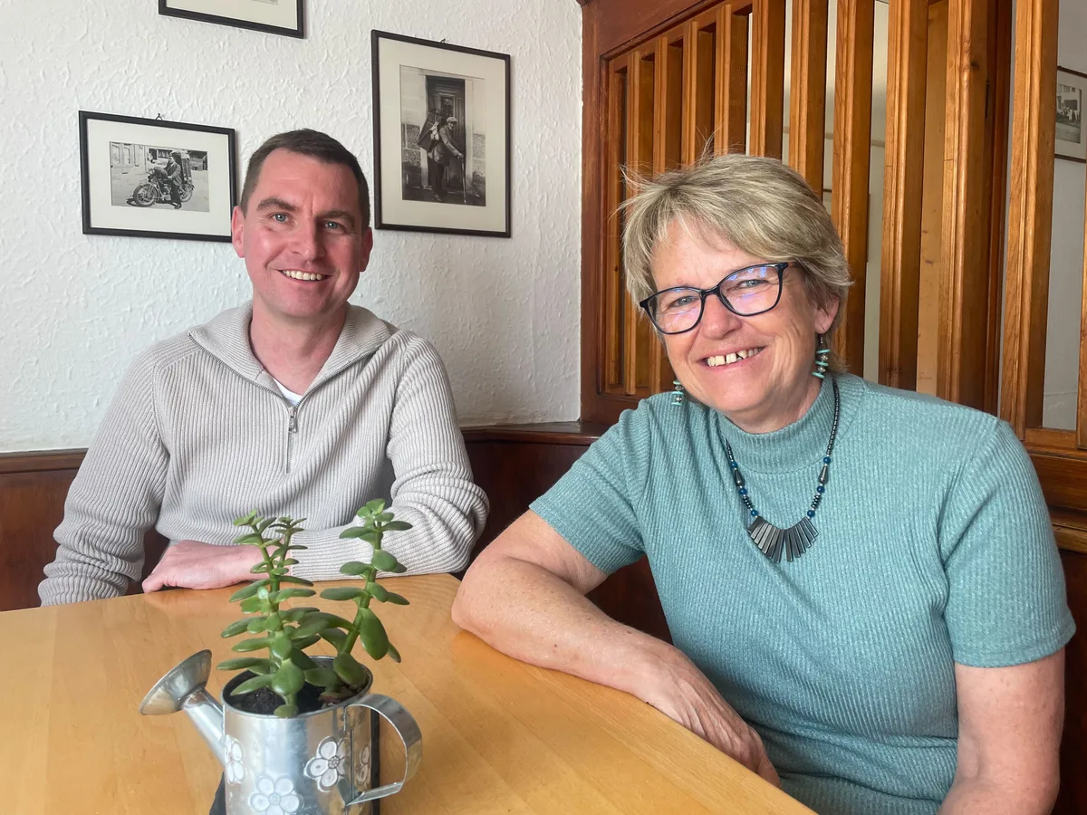 Madeleine Röck (rechts), hier mit Verwaltungsratspräsident Elias Furrer, wird dem «Frieden» trotzdem treu bleiben. Ein Mann und eine Frau sitzen an einem Tisch und lächeln in die Kamera.