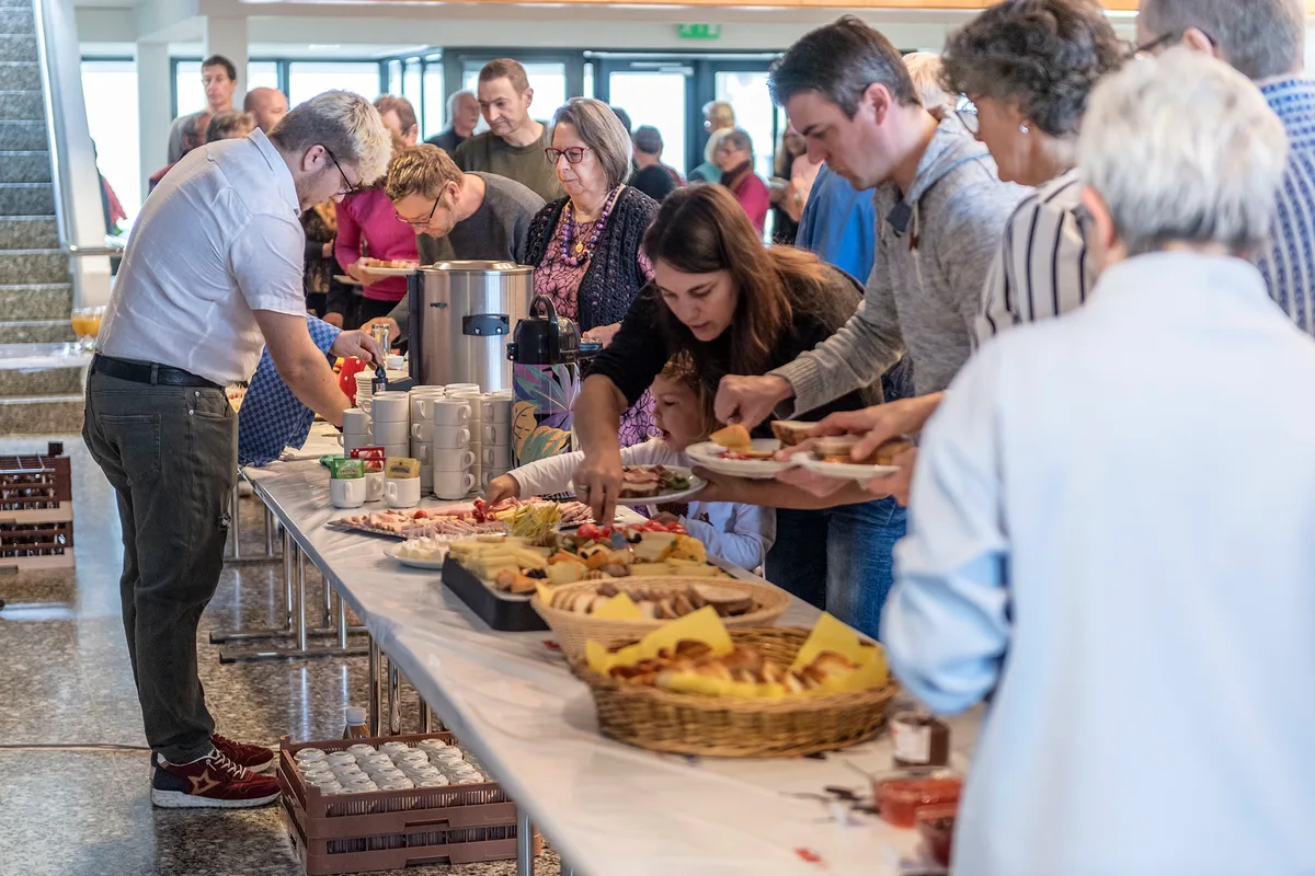 Die Anwesenden durften sich am Reichhaltigen Buffet bedienen. Man sieht Menschen am Buffet.