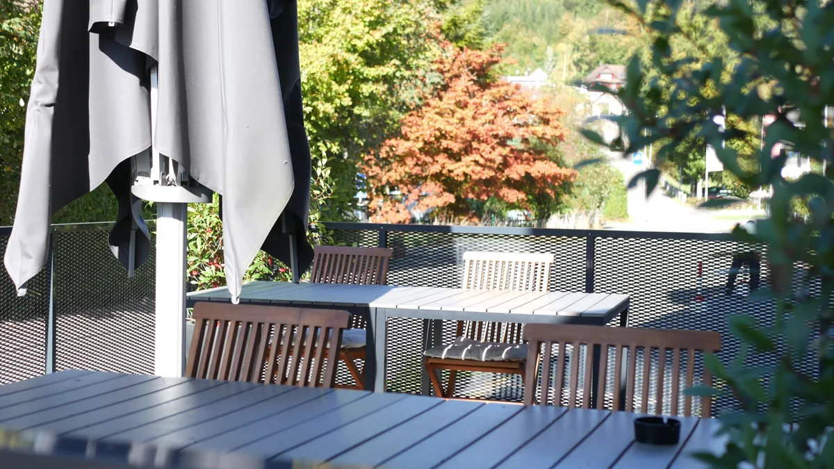 Blick auf einen kleinen Balkon mit Stühlen und Tischen.