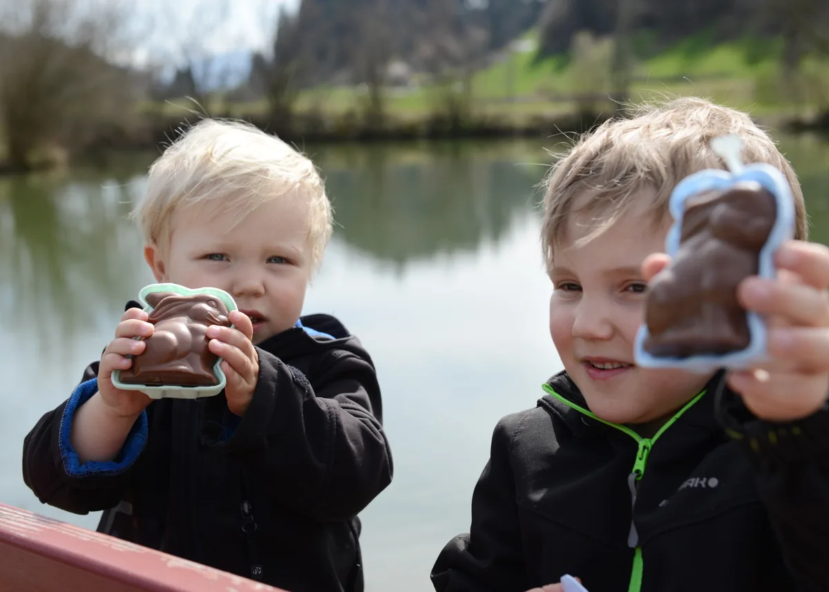 Für Finn und Tamo Knobel (von rechts) gab es zur Belohnung feine Schoggihasen. Man sieht zwei Buben mit ihren Schoggihasen.