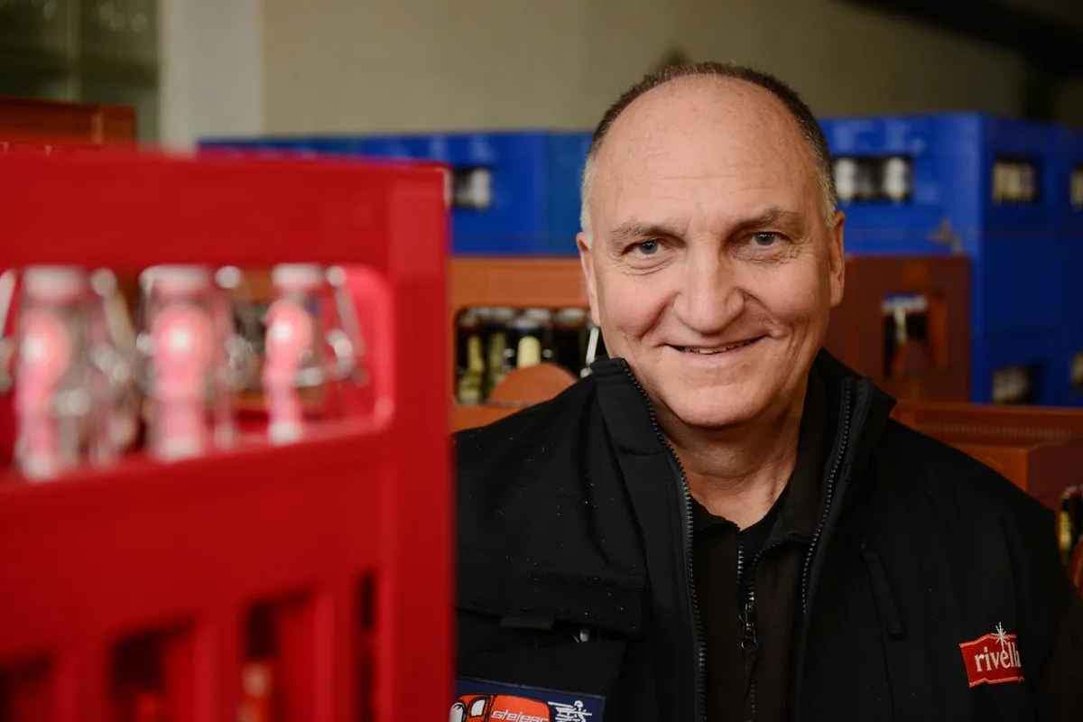 Für Peter Steiger sind auch Grossverteiler Konkurrenz. Man sieht einen Mann in einem Getränkelager.
