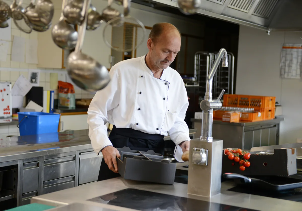 Mathias Krähenmann freut sich, dass die Anlagen im Restaurant noch gut in Schuss sind. Man sieht einen Mann in einer Restaurantküche.