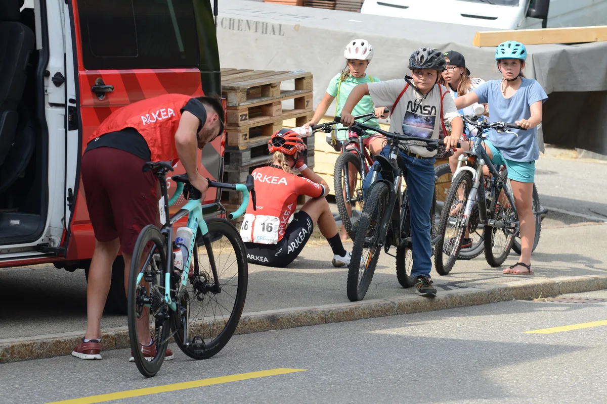Anaïs Morichon schafft den letzten Anstieg auf der Tösstal-Route nicht mehr. Schulkinder und ihr Team versuchen sie zu trösten. Die Frauen der Tour de Suisse fuhren am 19.06.2023 durch Fischenthal.