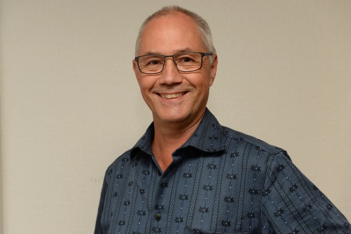 Daniel Schneiter im blauen Hemd, blickt in die Kamera.