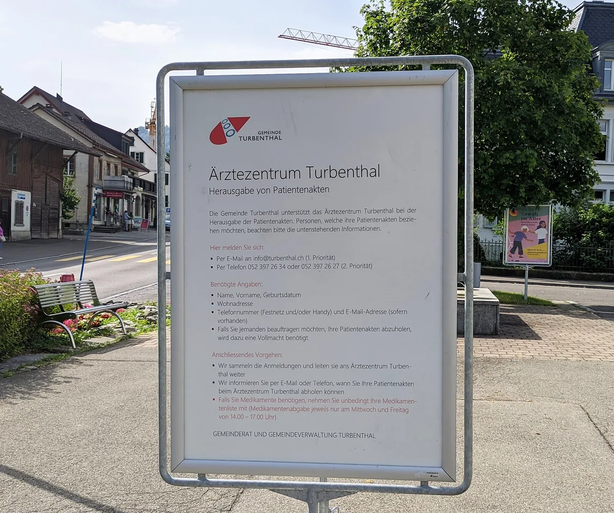 Die Informationen zu den Patientenakten stehen auch auf einem grossen Schild auf dem Gemeindehausplatz. Man sieht eine Tafel mit Informationen.