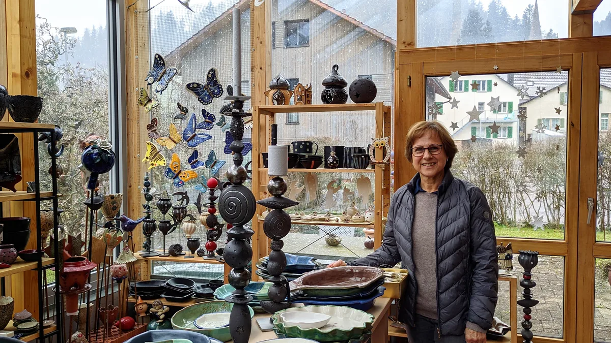 Kiener in ihrer Ausstellung im Wintergarten. Man sieht eine Frau in einer Ausstellung von Töpferwaren.
