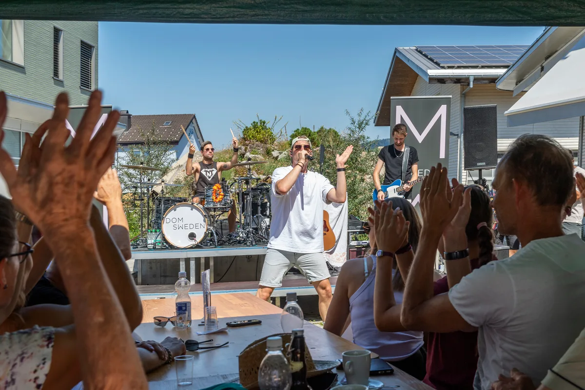 Dom Sweden performt nach dem Anschneiden des Rekordfladens. Ein Musiker spielt mit Band, Leute klatschen.