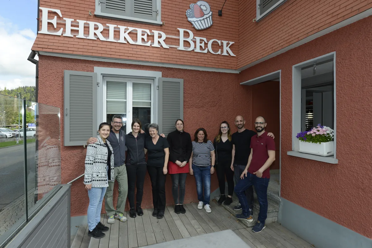 Neun Leute stehen vor dem roten Gebäude des Ehriker Becks.