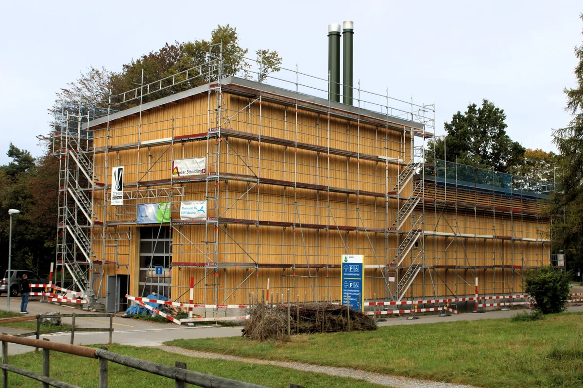 Man sieht eine Heizzentrale aus Holz. Es stehen noch Baugerüste.
