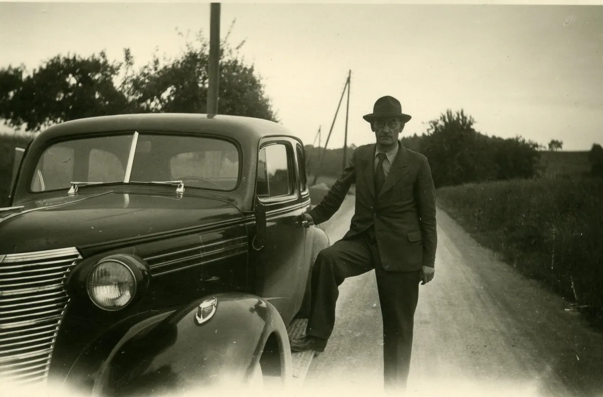 Jakob Wolfensberger lässt sich gerne mit Autos fotografieren. So wie hier 1949 mit seinem Chevrolet. Foto von Mann mit Hut neben Auto