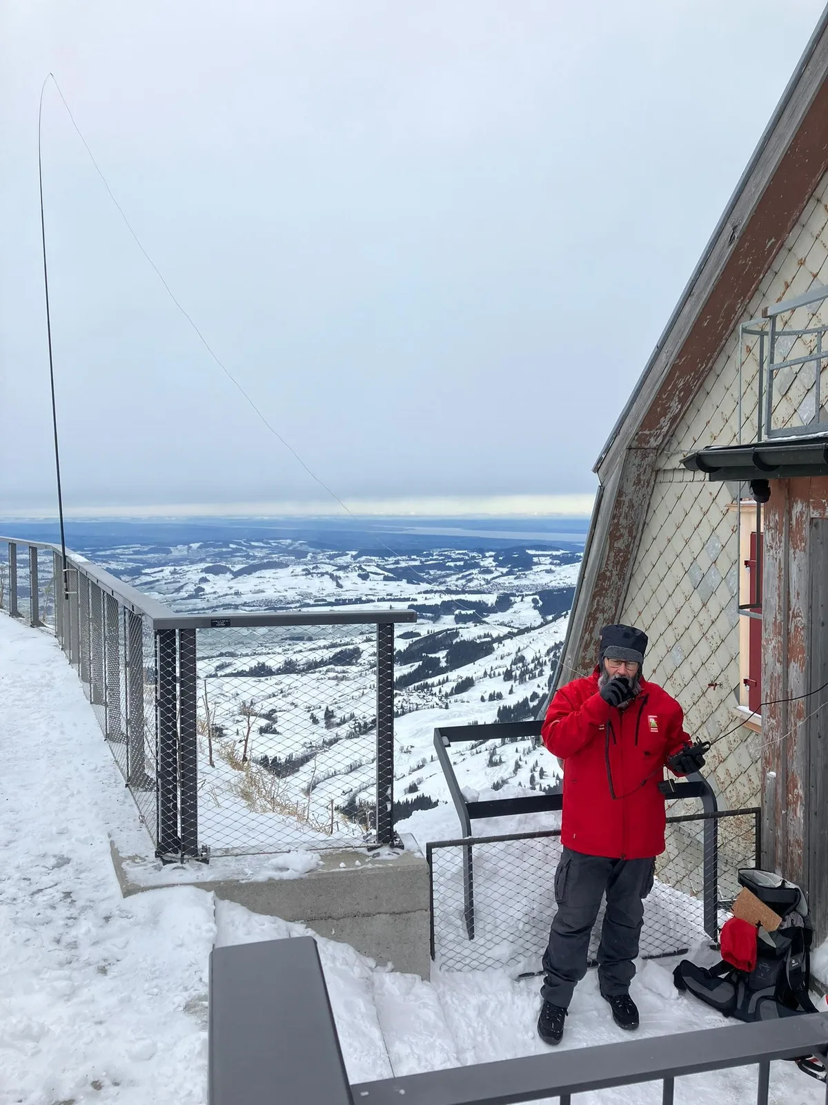 Man sieht einen Mann beim Funken auf einem schneebedeckten Berg.