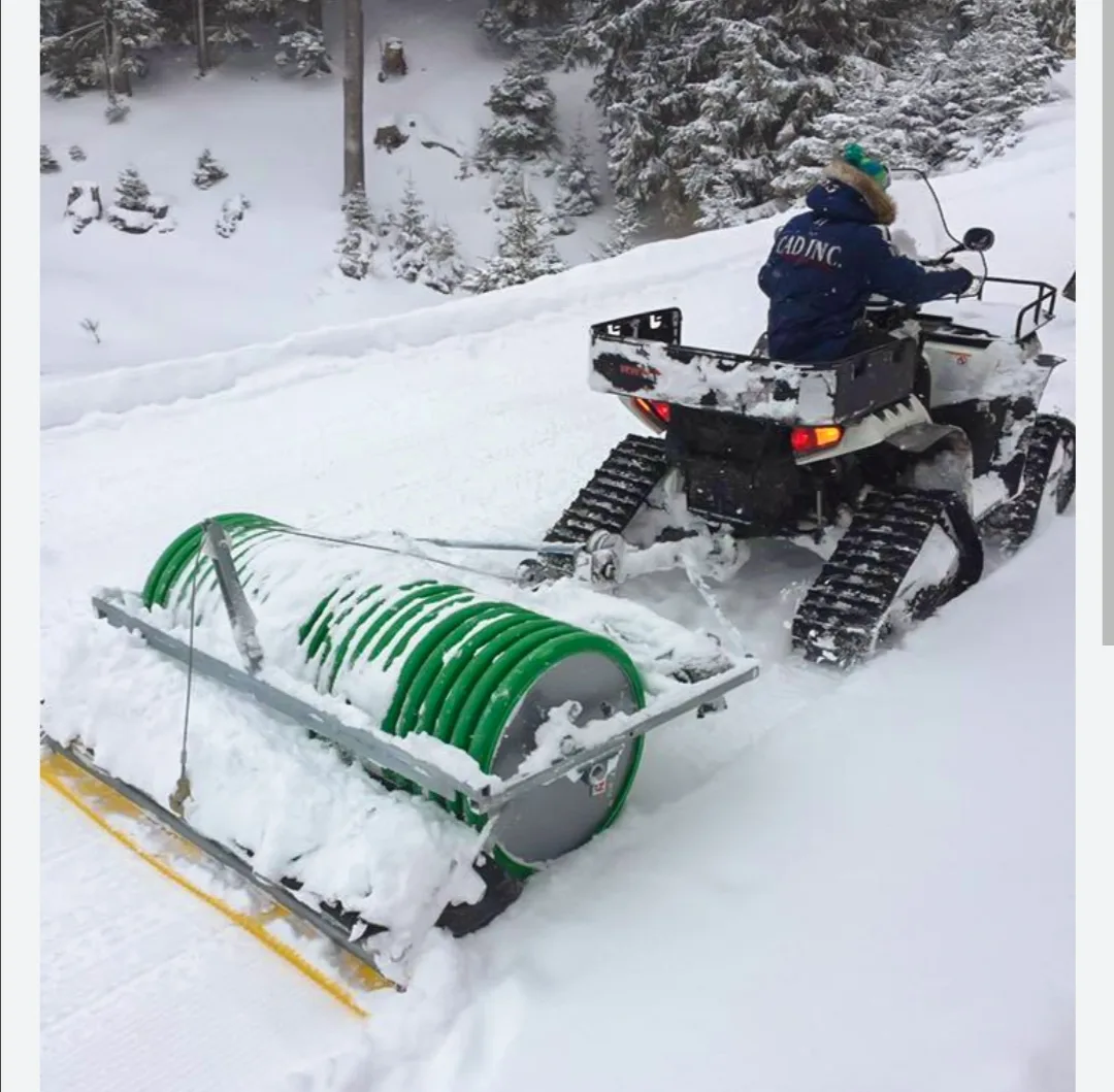 Mit der Schneewalze lässt sich die Piste auch bei wenig Schnee präparieren. Man sieht einen Schneetöff mit Schneewalze im Schnee.