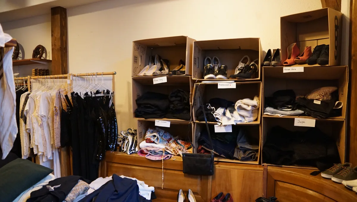 Man sieht Kleider in einem Secondhand-Laden.