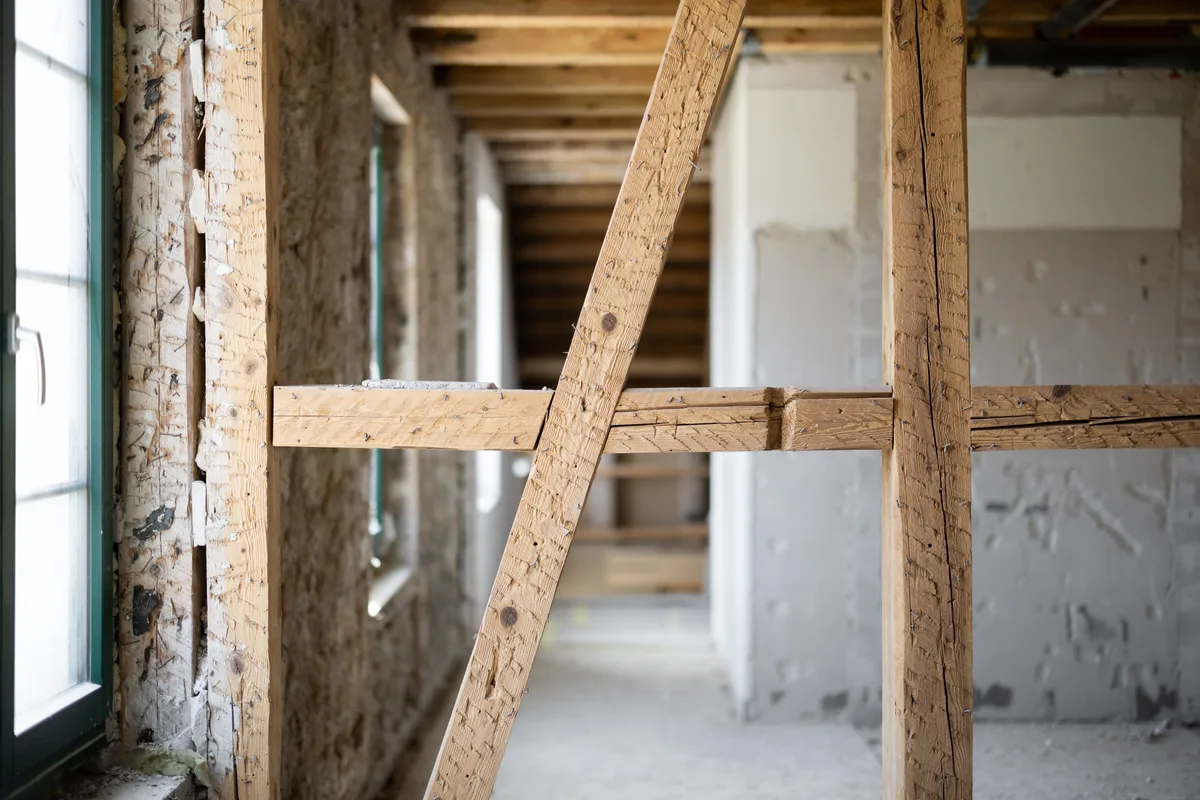 Man sieht Fachwerkbalken in einem im Bau befindlichen Haus.