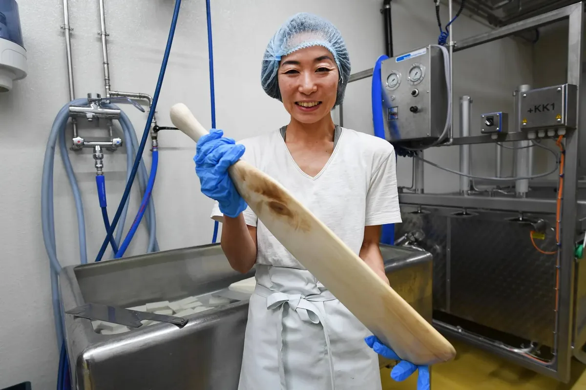 Die Holzkelle hat sich Yumemi Ito extra nach japanischem Vorbild anfertigen lassen. Man sieht eine Frau mit einer Holzkelle. Sie trägt Arbeitskleidung und ein Haarnetz.