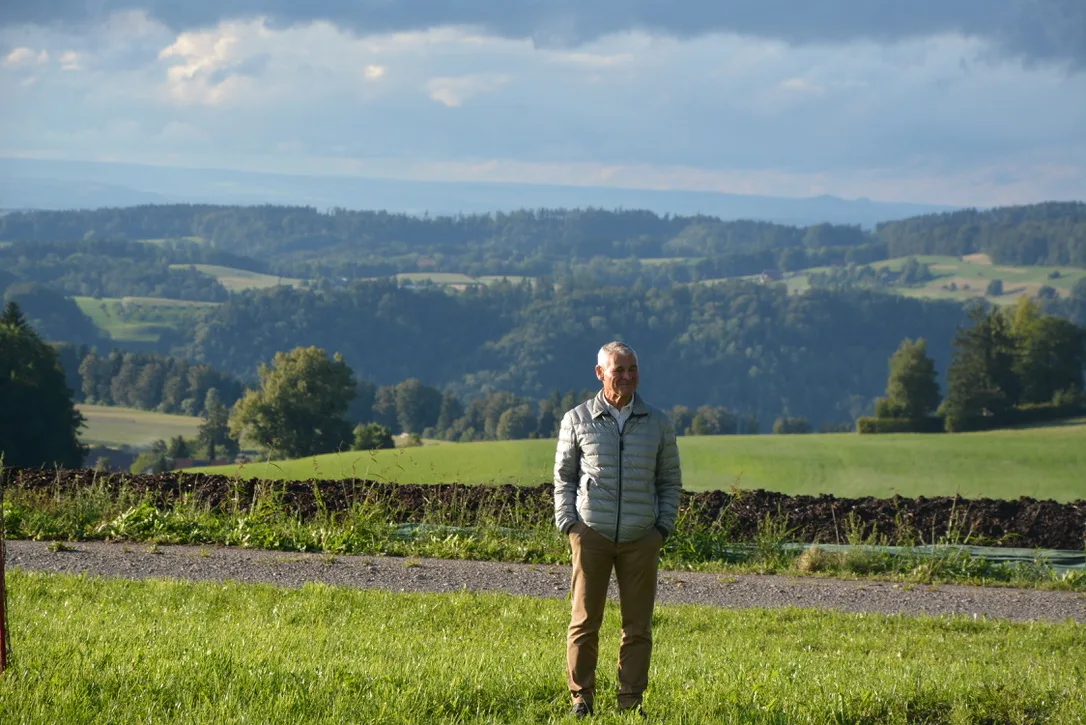 Man sieht einen Mann auf einer Wiese stehen.