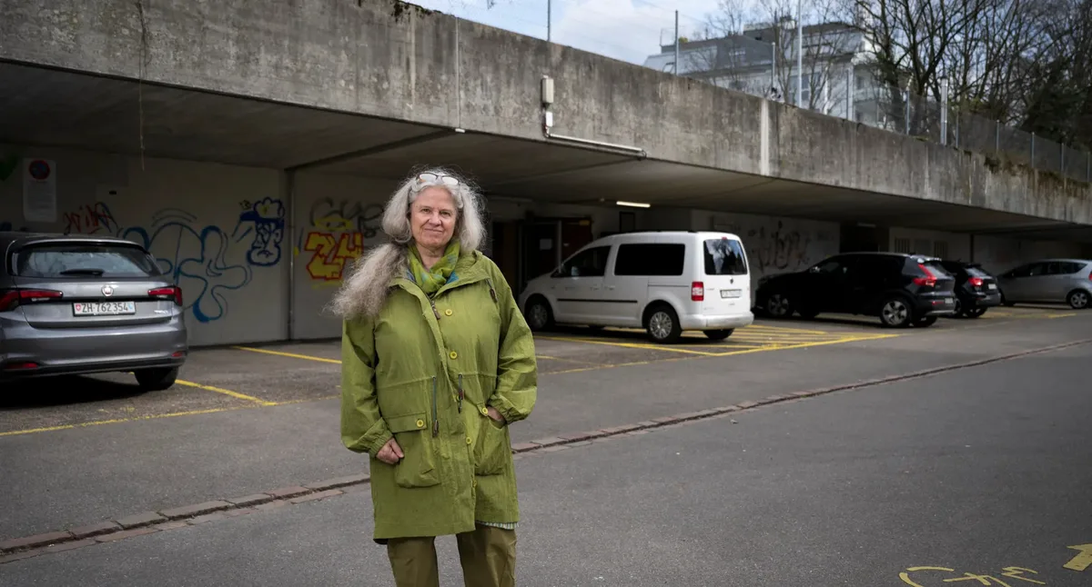 Man sieht eine Frau vor einem überdachten Parkplatz.