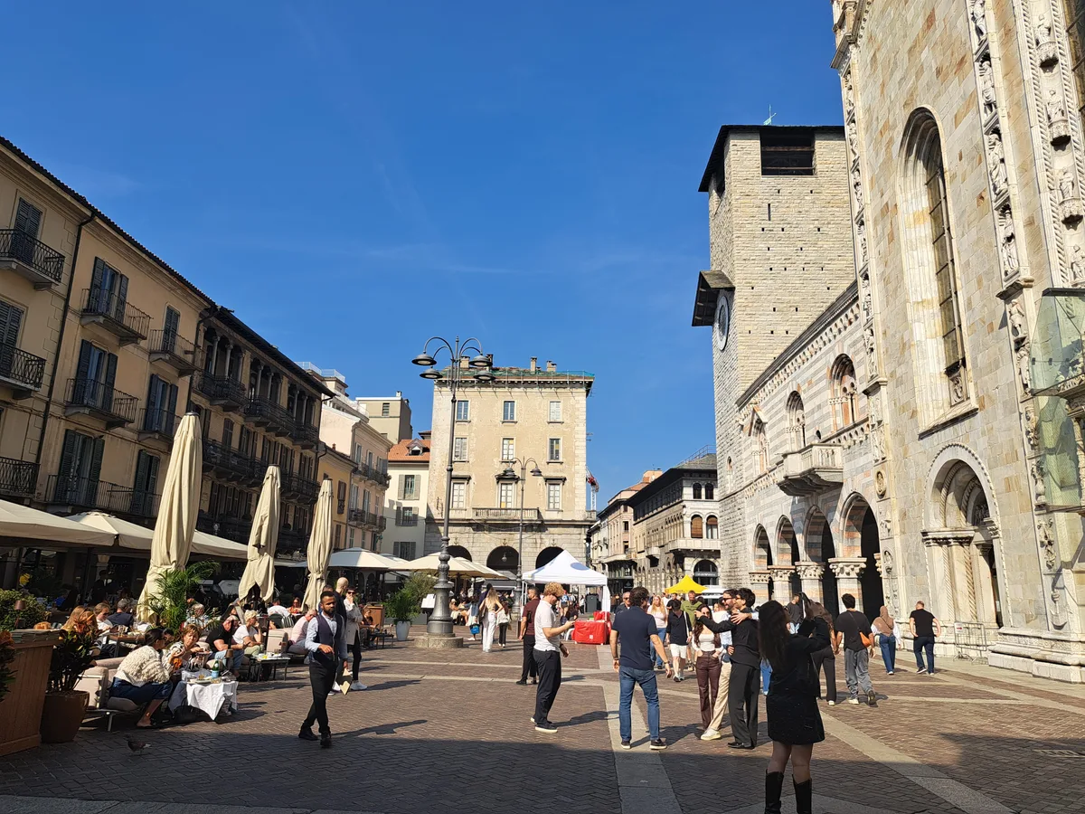 Auf der Piazza del Duomo treffen sich Einheimische wie auch Touristen. Platz mit Häusern und Menschen
