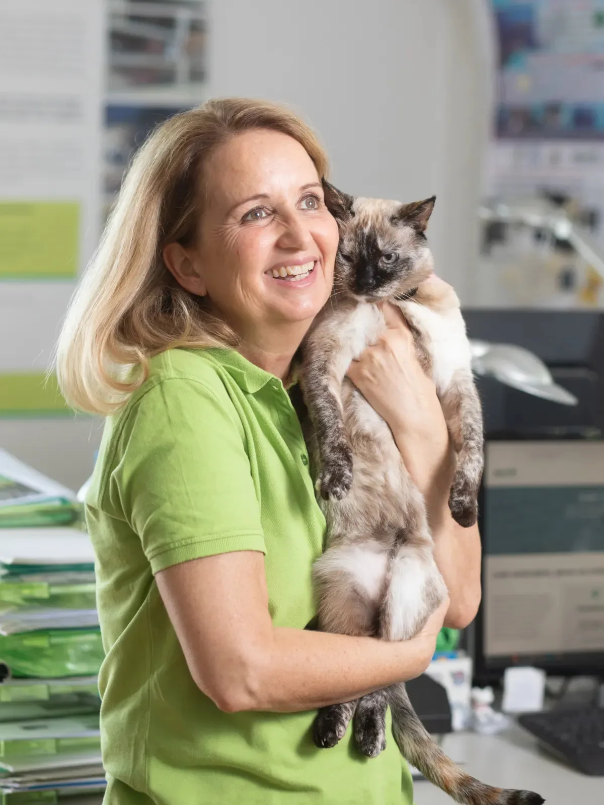 Man sieht eine Frau mit einer Katze auf dem Arm.