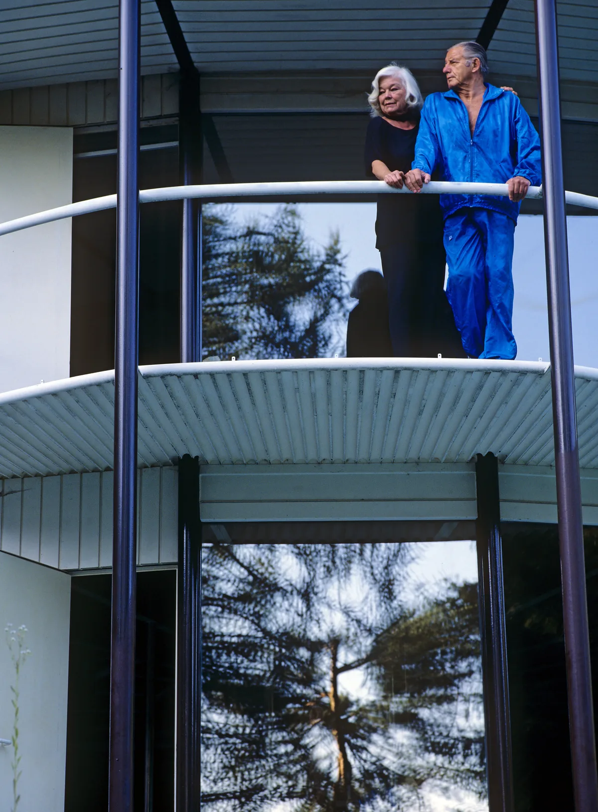 Ein Paar steht auf einem Balkon der Villa.