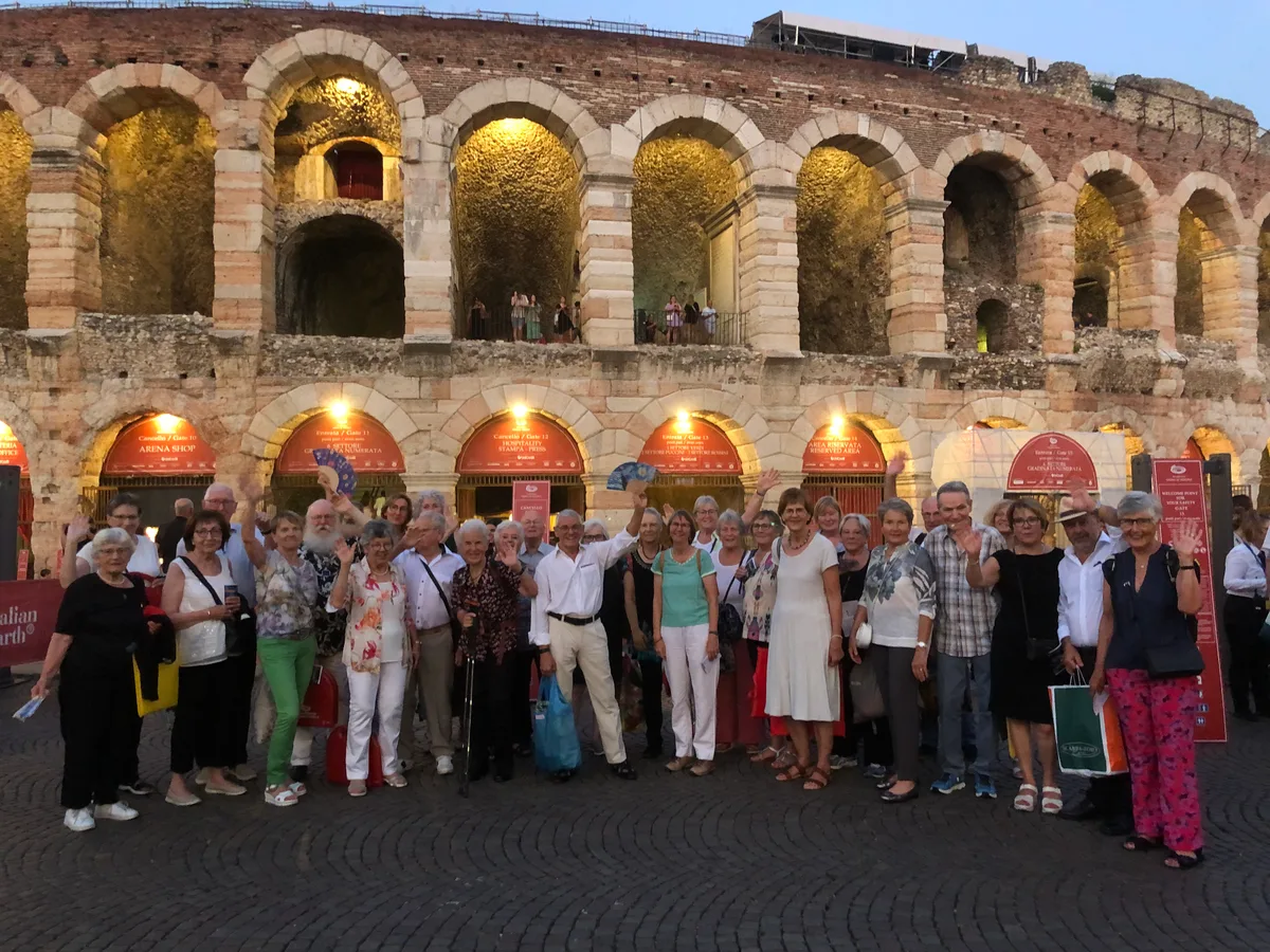 Eine Reisegruppe steht vor der Operarena in Verona.