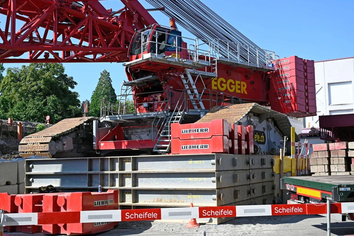 Der Raupenkran sitzt auf einem provisorischen Fundament aus Stahl und Betonklötzen. Raupenkran auf Provisorium.