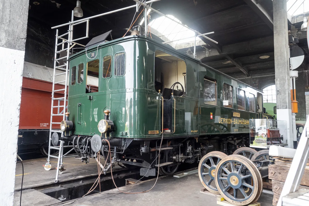 Der Dampftriebwagen ist in der Schweiz der letzte seiner Art. Man sieht einen grünen Dampftriebwagen, der eingerüstet ist.